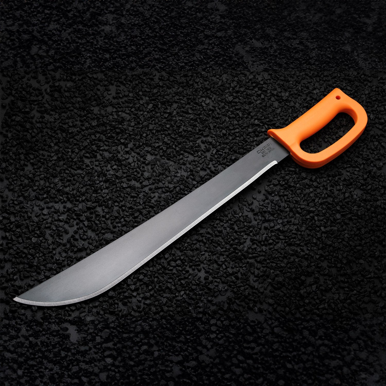 Okapi machete with D-ring hand guard and Okapi Orange grip shown in forest setting