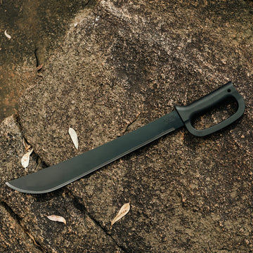 Okapi D-Ring machete with black tactical handle displayed in outdoor setting