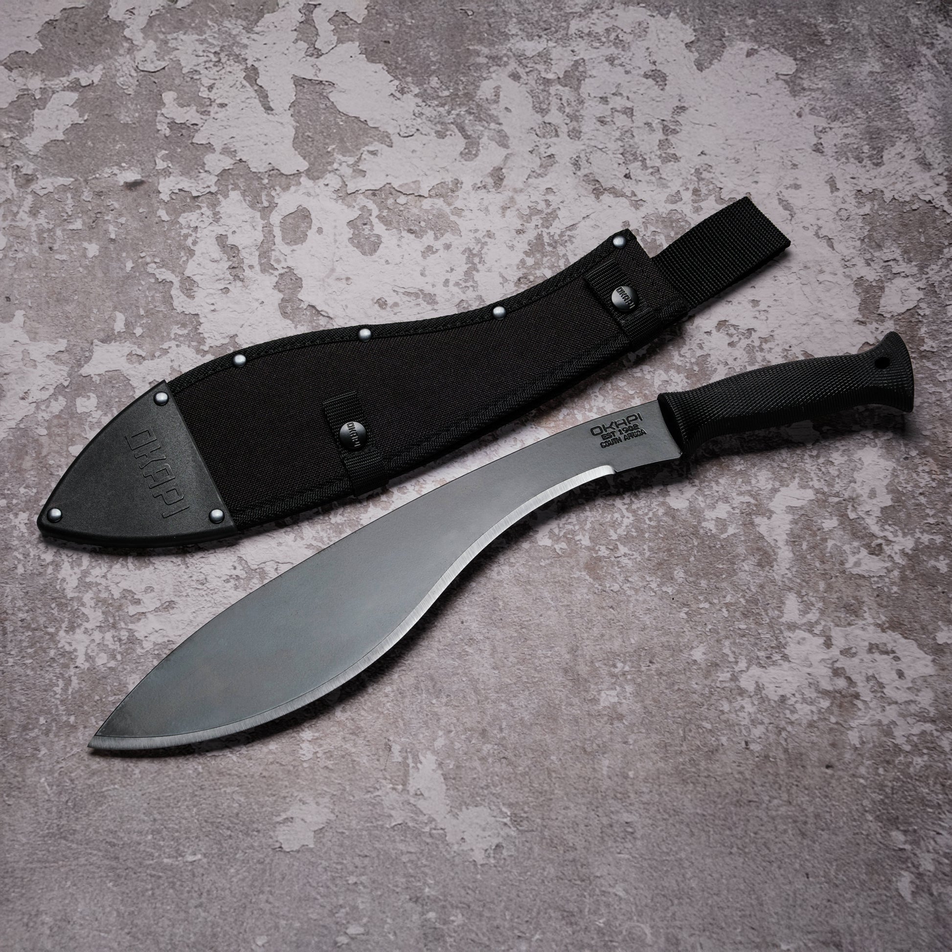 Okapi Kukri Machete with black handle with black Sheath on grey background