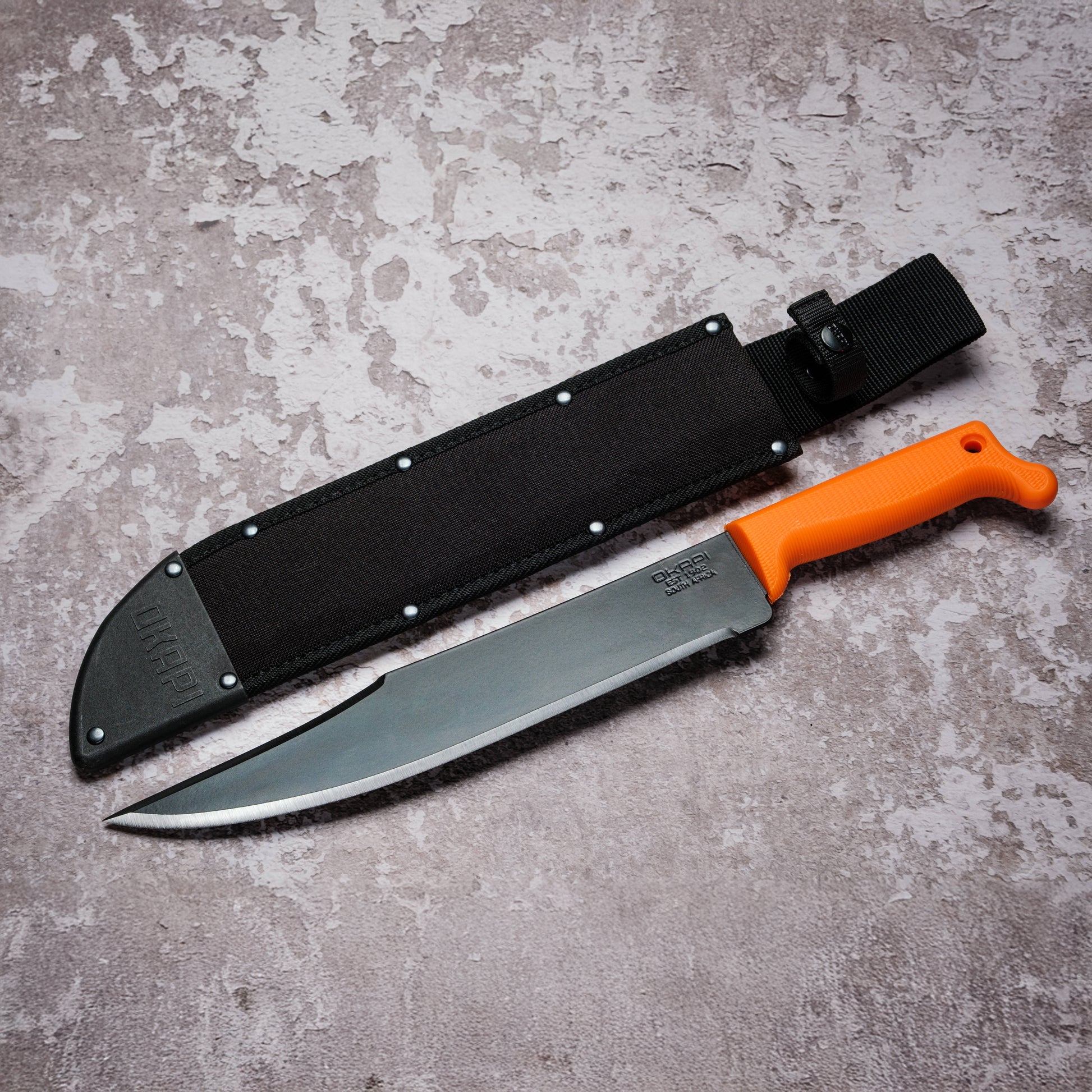 Okapi Bowie Machete with Okapi orange handle and black sheath cover on grey background