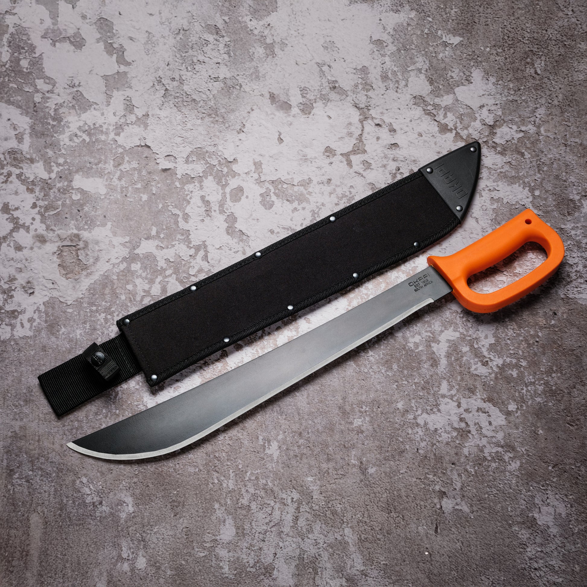 Okapi D-Ring Machete Okapi orange handle with black Sheath on grey background