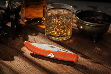 Okapi Orange Folding Knife Folded on wooden background
