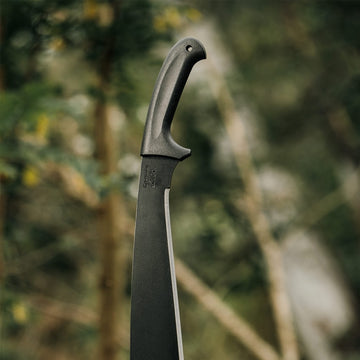 Okapi Jungle machete featuring black handle, showcased in rugged outdoor backdrop