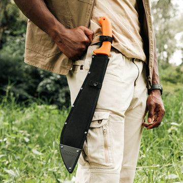 Okapi jungle machete in sheath, Okapi orange handle resting against hip