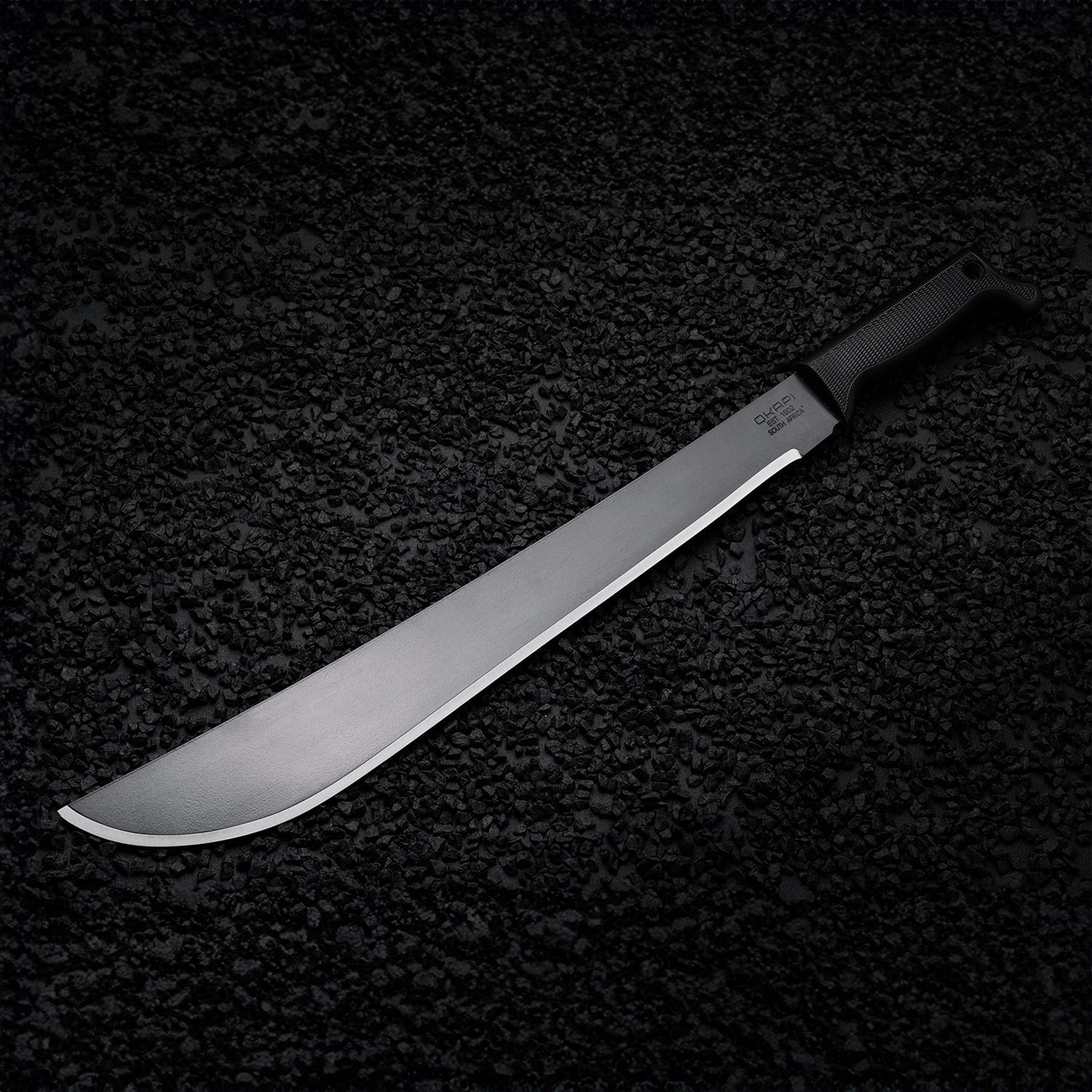 Black-handled Okapi Latin machete placed on rugged rock environment