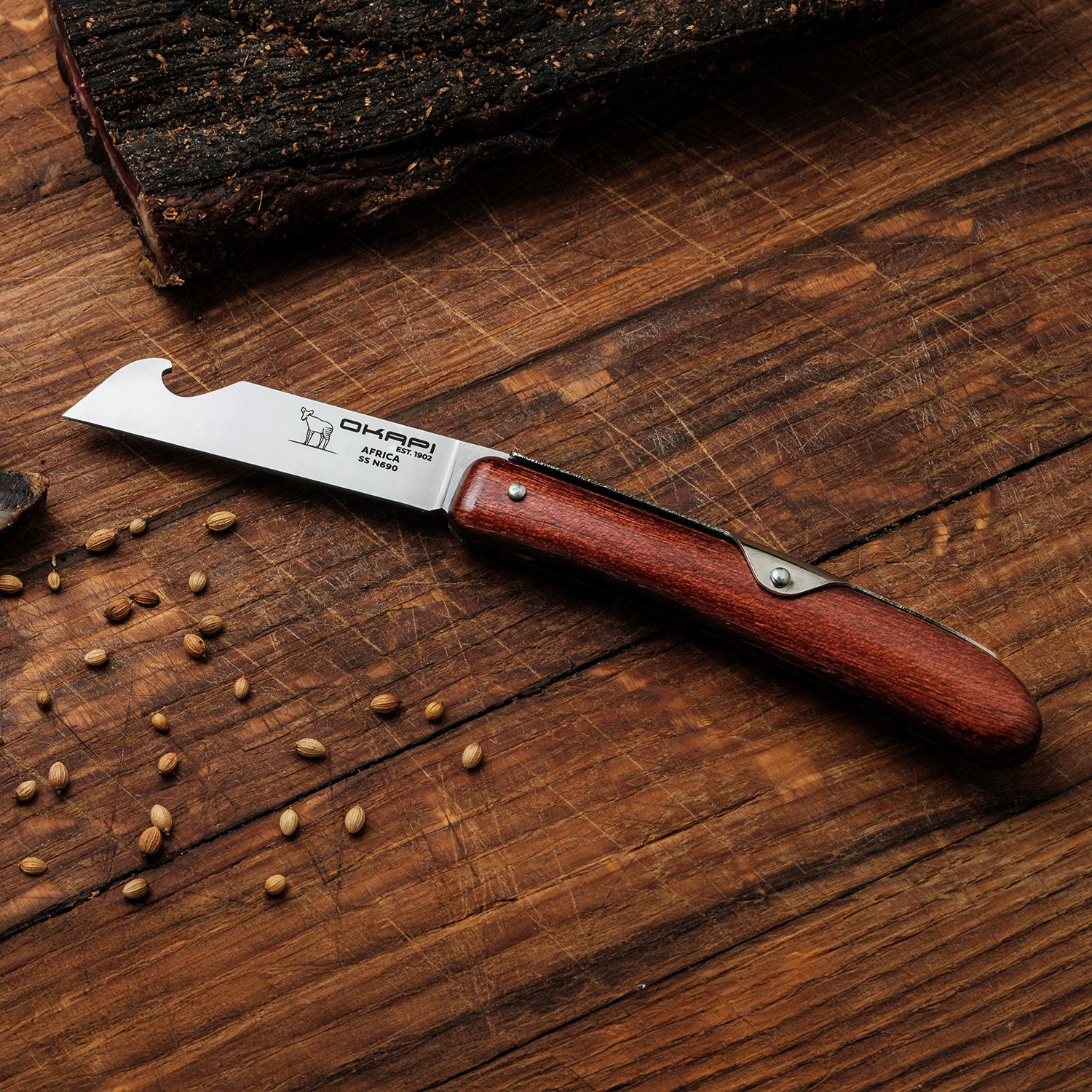 Okapi Biltong Knife with wooden handle with biltong in the background