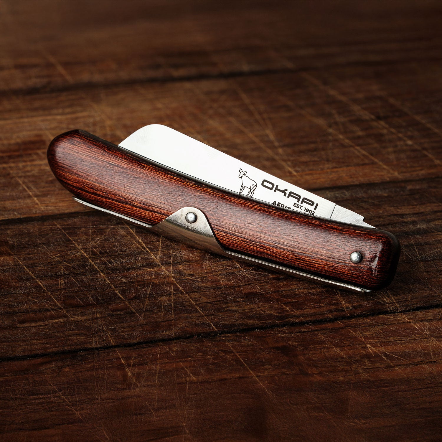 Close-up Okapi Biltong Knife folded on wooden background