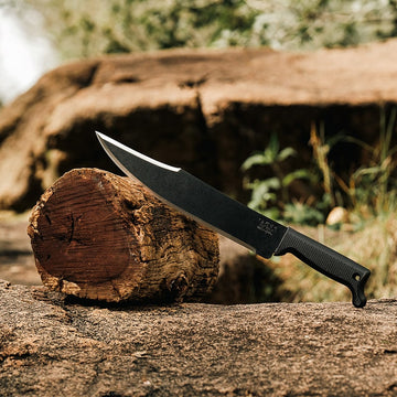Okapi outdoor machete with Bowie blade and Tactical Black grip in natural terrain