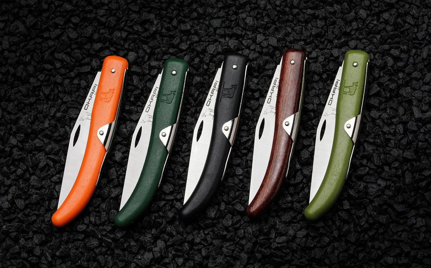 Close-Up Closed Okapi folding knife with different coloured handles on black stone background