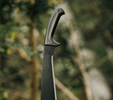 Lifestyle image of Okapi Jungle machete placed on ground in forest setting